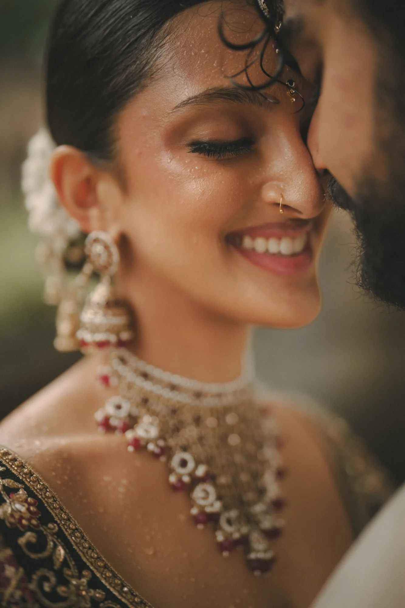 A bride smiling as her groom leans in after the ceremony