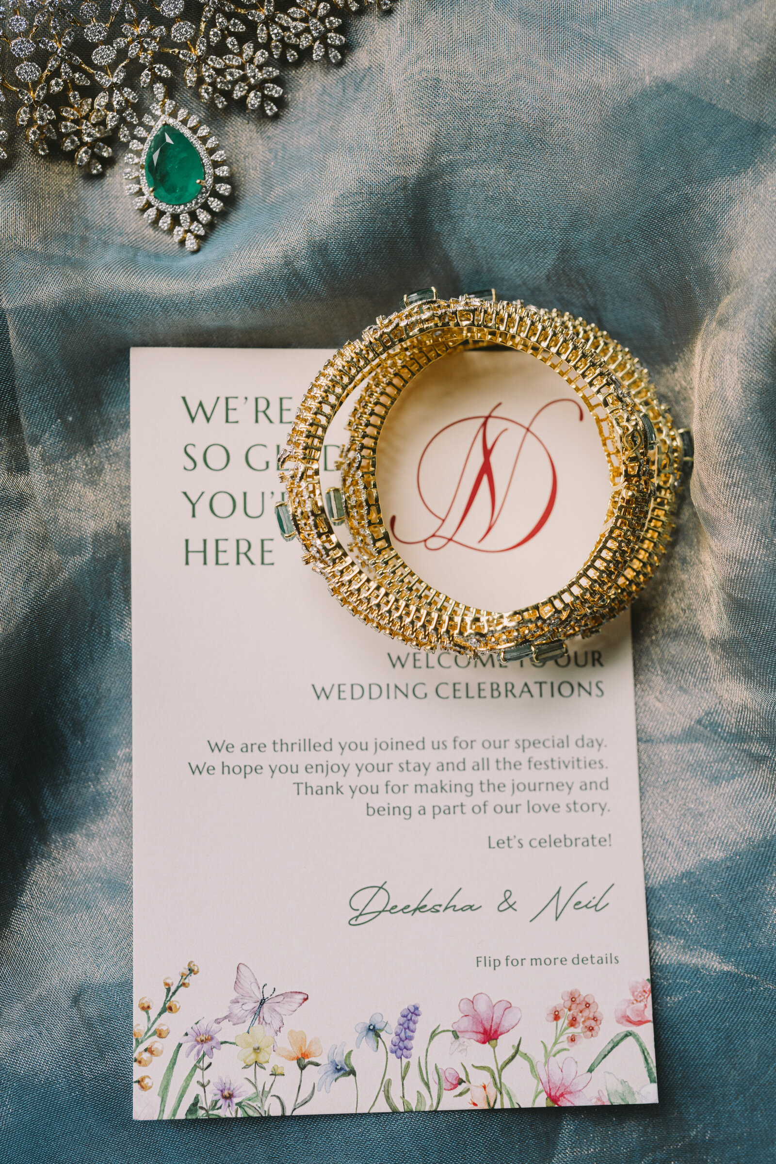 Wedding invitation styled with emerald and gold bridal jewellery